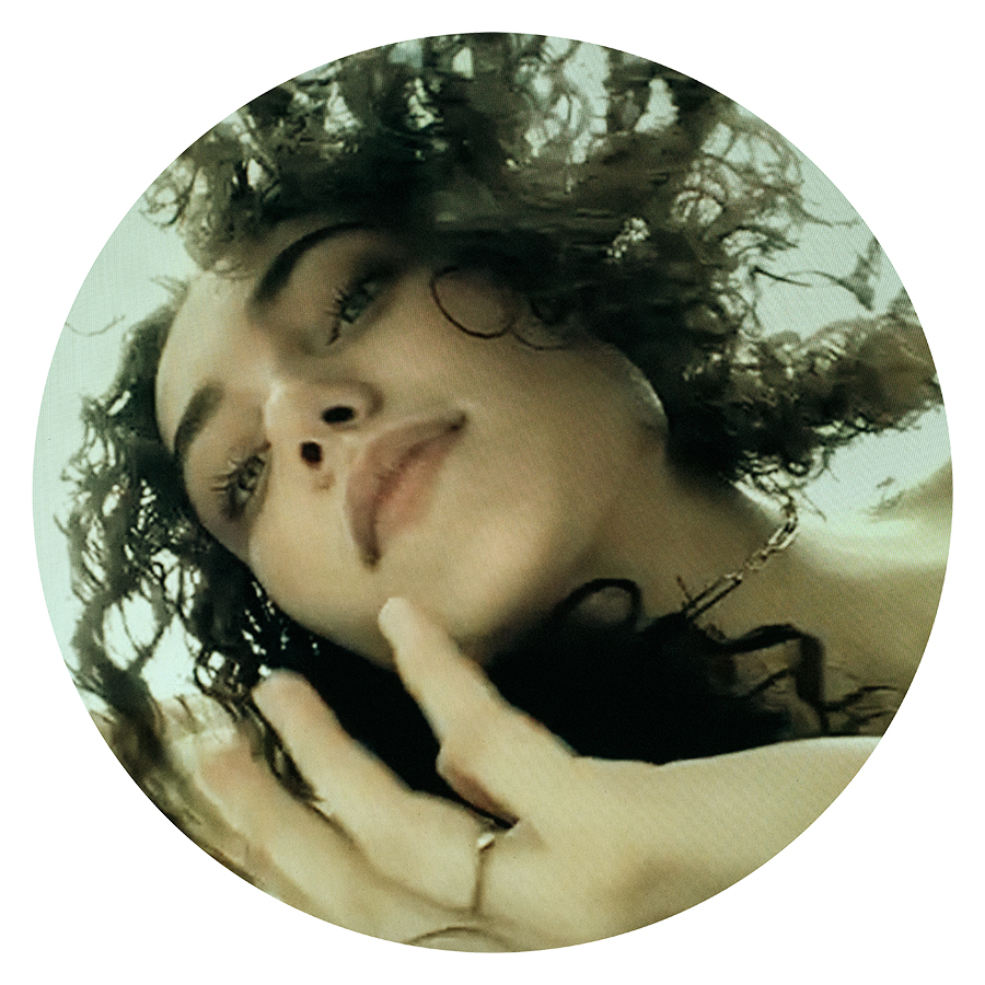 Circular image of model Anna Bray with wavy hair photographed by Joshua Pyles