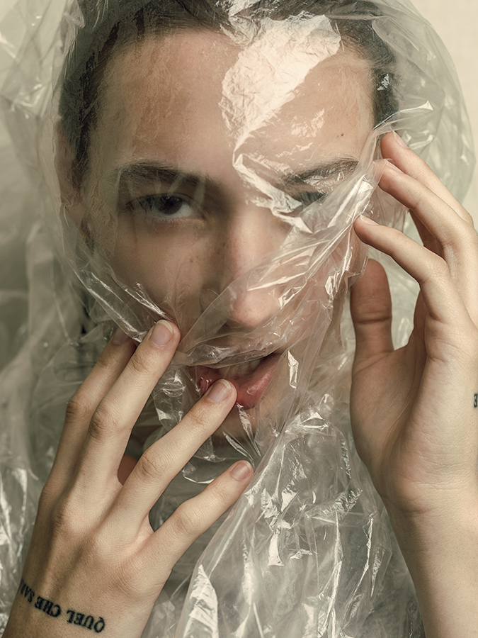 Model Tehya McDonald posing with a sheet of plastic over her face photographed by Joshua Pyles